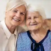 Smiling elderly woman with a caregiver providing compassionate respite care at home in Ireland.